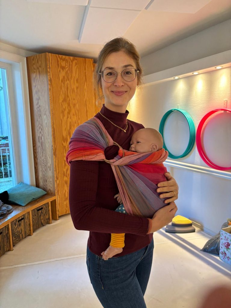 Trageberaterin Kateryna Kaune mit einem Baby in der Trage